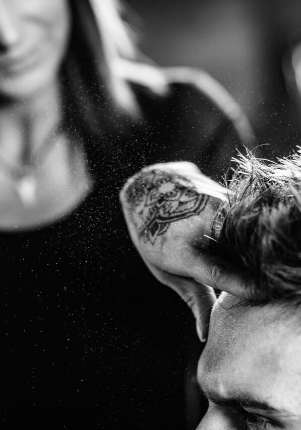 Hair styling man in hairsalon by female hairdresser