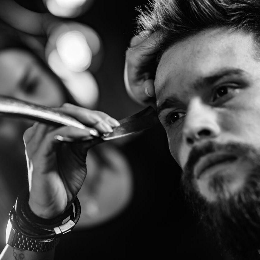 Hair styling man in hairsalon by female hairdresser