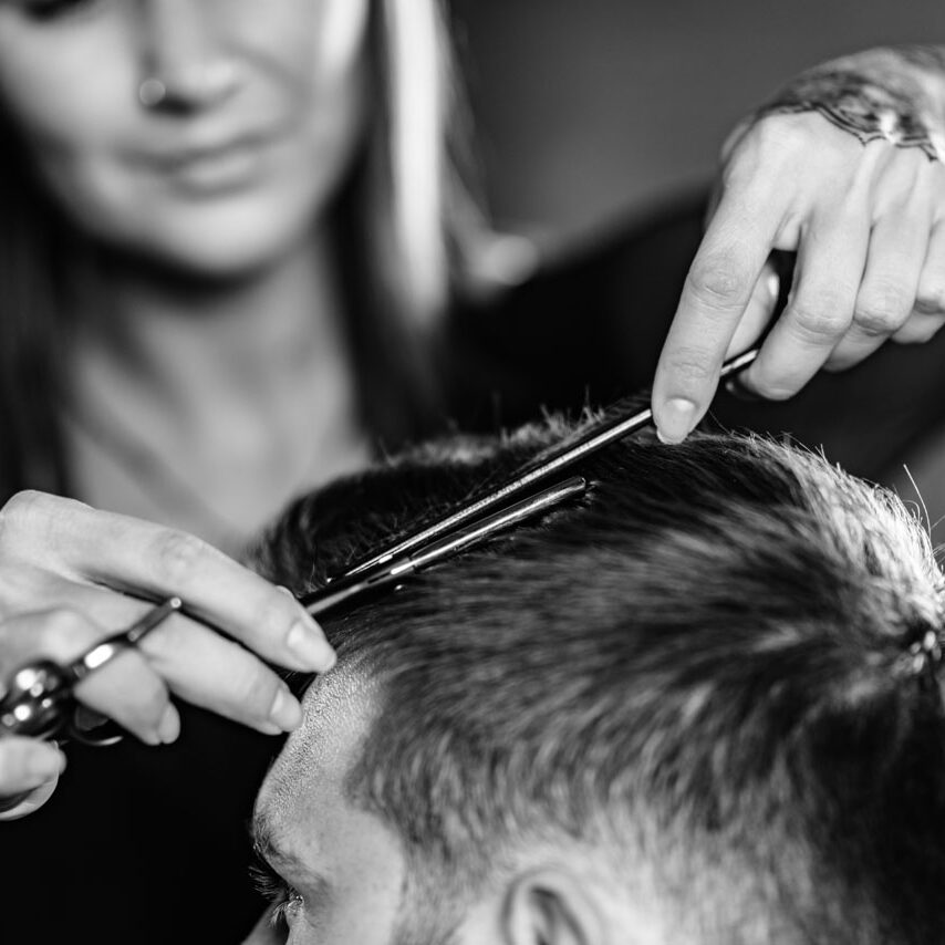 Hair styling man in hairsalon by female hairdresser